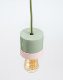 Decorative lamp with a green base and pink accent on a white background