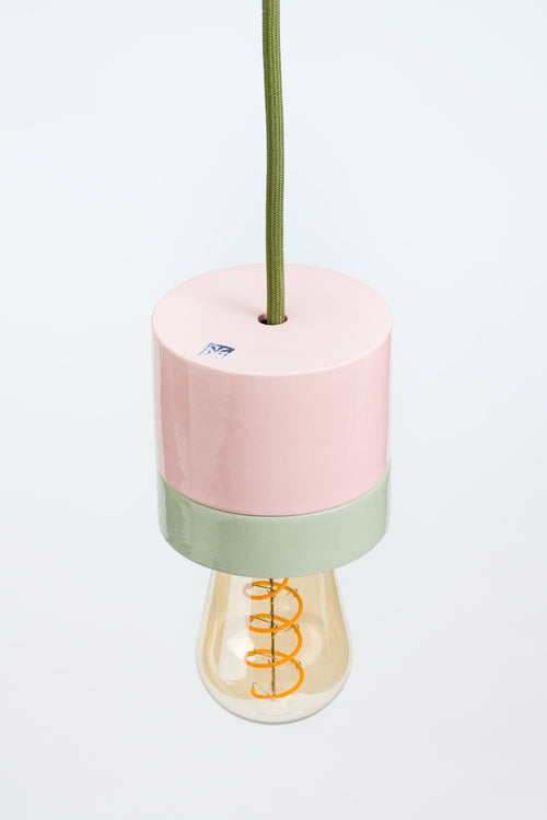 Decorative lamp with pink and green base on a white background