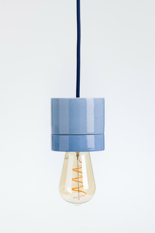 Blue pendant light with a visible bulb on a white background