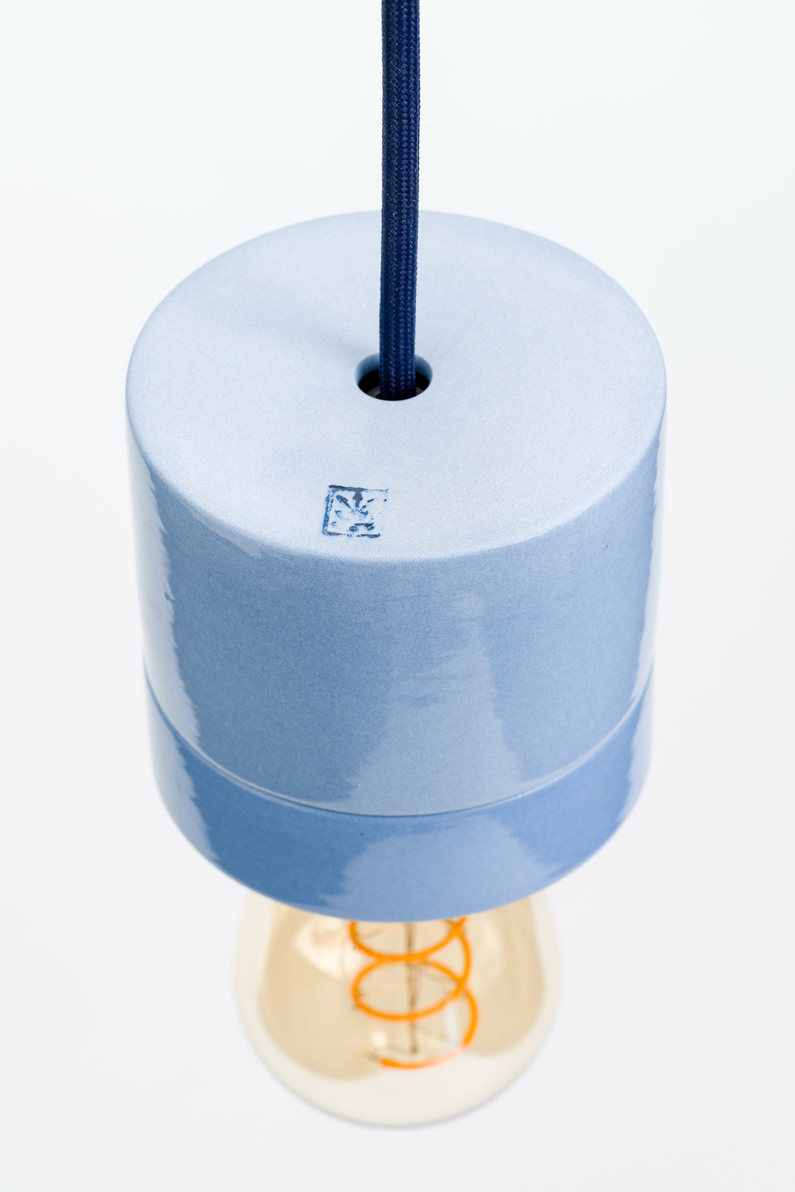 Blue pendant light with a visible brand logo on a white background
