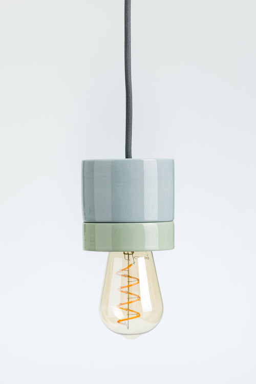 Modern pendant light with a gray and green shade on a white background