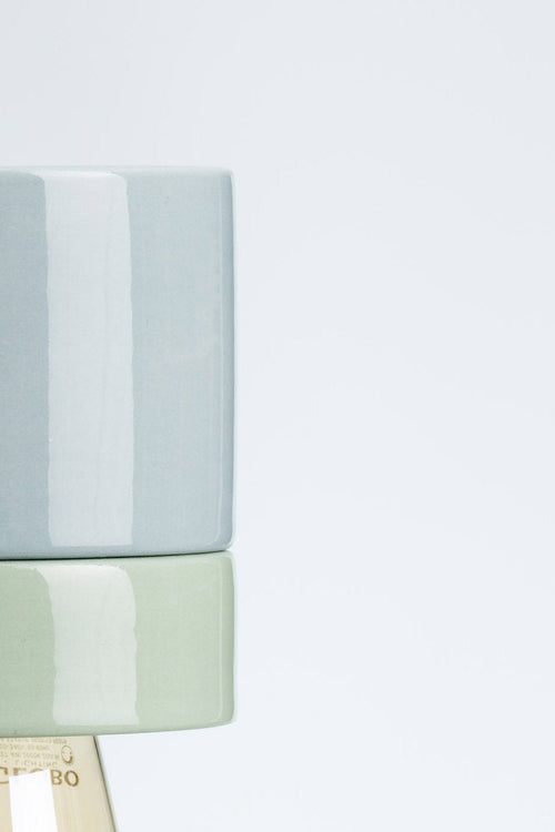 Modern pendant light with a gray and green shade on a white background
