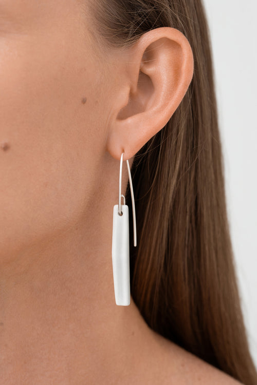 
Matt white porcelain statement earring with custom 925 sterling silver. Handcrafted by IAC member Márton Strohner. Limited series, made to order. STUDIO MASTRO
